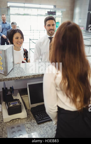 Passagiere warten in der Schlange am Check-in Schalter Stockfoto