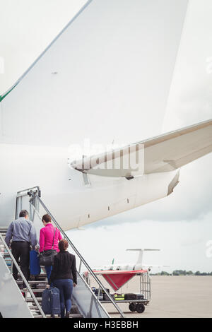 Passagiere auf der Treppe klettern und das Flugzeug betreten Stockfoto