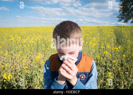 Junge, Niesen und die Nase weht und Pollenallergie leiden. Stockfoto