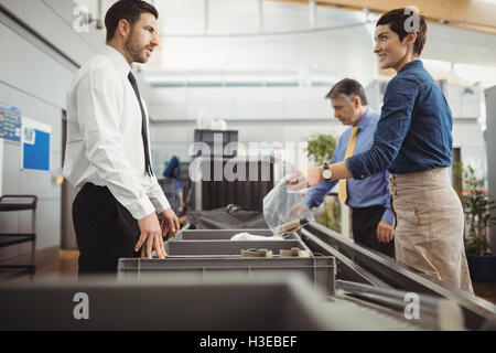 Passagier putting Plastiktüte in Fach für Sicherheit überprüfen Stockfoto