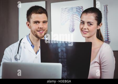 Physiotherapeuten, die Wirbelsäule Röntgen, Patientin zu erklären Stockfoto