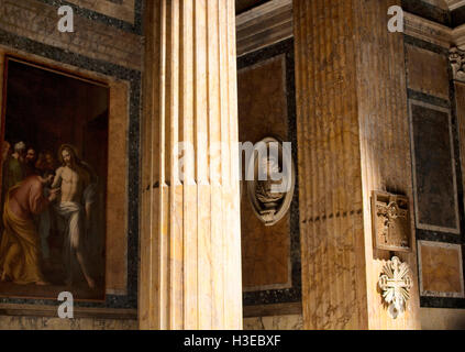 Blick auf innerhalb des Pantheon. Eine Spalte, Statue, religiöse Objekte und Gemälde sind in der Ansicht. Licht, das von oben schafft dram Stockfoto