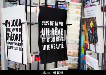 Nahaufnahme des französischen Postkarten auf Gestellen über Humor auf Rue Montorgueil in Paris Straße. Stockfoto