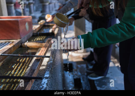 Touristischen Dame waschen Hand vor Eintritt in den japanischen Tempel. Stockfoto