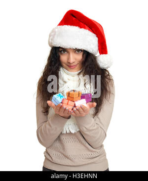 Mädchen in Santa Hut Porträt mit Handvoll kleine Geschenkboxen posiert auf weißem Hintergrund Weihnachten Ferienkonzept, glücklich und Em Stockfoto