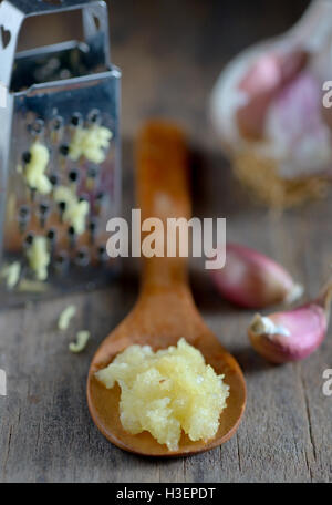 Knoblauch in Löffel auf hölzernen Hintergrund Stockfoto