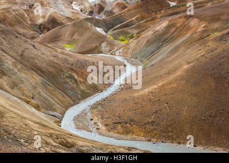 Fluss mit roten Hügeln und schwarze und rote Lava, die verschneiten Berge in Kerlingarfjoll auf Island. Stockfoto