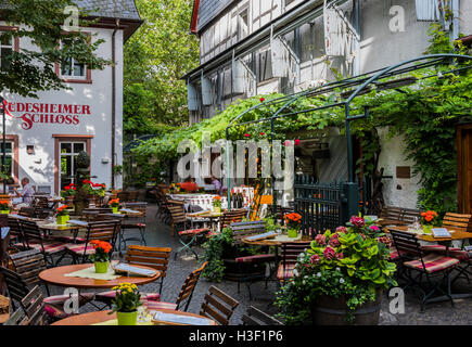 Rüdesheim, Deutschland - August 20,2016: Terrasse mit Holzstühlen und Tischen von Rudesheimer Schloss in Rüdesheim nahe dem Rhein. Stockfoto