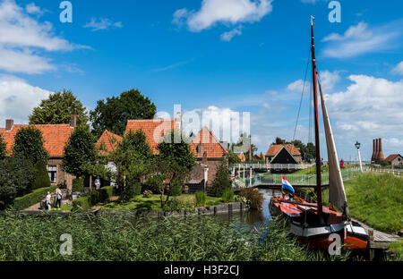 Enkhuizen, Niederlande - 9. August 2016: Zuiderzee Museum Enkhuizen mit alten Fischerhaus, Fischerboot und Kleinstadt. Stockfoto