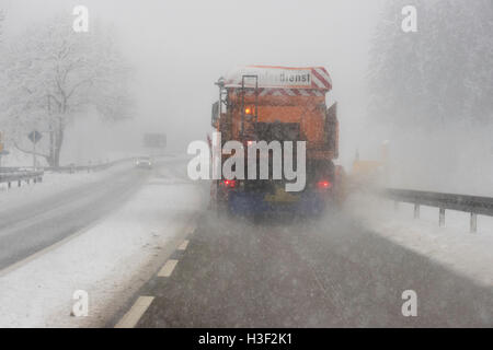 LKW entfernt Straße in Deutschland bei schlechtem Winterwetter Schnee. Stockfoto