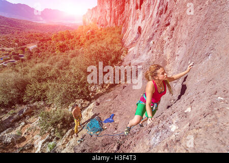 Junge schöne weibliche Kletterer, die aufsteigenden Felswand Stockfoto