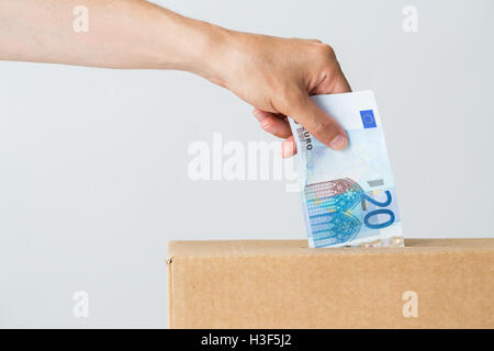 Mann, Euro-Geld in die Spendenbox Stockfoto