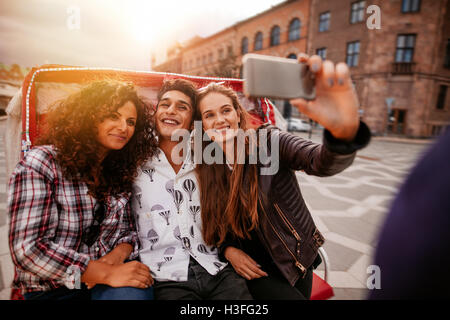 Teenager Freunde nehmen Selfie auf Dreirad. Junger Mann und Frauen reiten auf Dreirad Fahrrad und unter Selbstporträt. Stockfoto