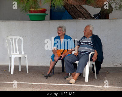 Ein älteres Ehepaar in der Ortschaft Avlemonas auf der griechischen Insel Kythira draußen sitzen. Stockfoto