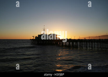 Santa Monica Pier mit Sonne Einstellung hinter Gebäude. Stockfoto