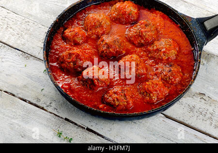 Schwenken Sie Rindfleisch Frikadellen mit einer würzigen Tomatensauce in Eisen. Stockfoto