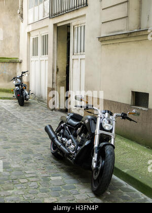 Zwei leistungsstarke Motorräder (Harley Davidson im Vordergrund) geparkt in Paris, Frankreich Stockfoto