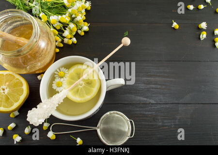 Kamillentee mit Zitronenscheiben und Blumen Stockfoto