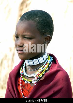 Porträt von Masai Mädchen tragen traditionelle rote Decke und handgemachte Perlenketten genommen in Tansania Stockfoto