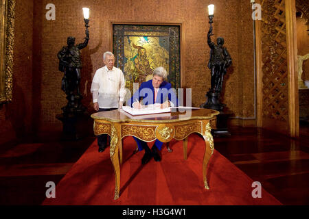Philippinen Foreign Secretary Perfecto Yasay Uhren als US-Außenminister John Kerry das Gästebuch in der Malacañang Palace in Manila, Philippinen, am 27. Juli 2016, bevor die Sekretärin ein Arbeitsessen mit Philippinen Präsident Rodrigo Duterte statt unterzeichnet. Stockfoto