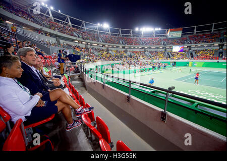 US-Außenminister John Kerry sitzt mit eingehenden United States Tennis Association Präsident Katrina Adams, als sie US Tennis spielen Spieler Venus Williams belgischer Tennisspieler Kirsten Flipkens am 6. August 2016, bei einem Olympischen Tischtennis im Olympiapark in Rio de Janeiro, Brasilien sahen, beobachtet von Kerry und Kolleginnen und Kollegen der US-Präsidentschaftswahlen Delegation an den Olympischen Spielen 2016. Stockfoto