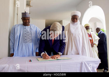 US-Außenminister John Kerry, beobachtet von Sultan Muhammadu SA Abubakar und Gouverneur von Sokoto Aminu Waziri Tambuwai unterschreibt ein Gästebuch nach der Lieferung einer Rede über die gewalttätigen Extremismus und die Förderung von good Governance nach einem Treffen mit den Beamten und religiösen Führer auf der Palast des Sultans in Sokoto, Nigeria, am 23. August 2016. Stockfoto