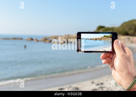 Geschäftsmann am Strand arbeiten mit Notebook und smartphone Stockfoto