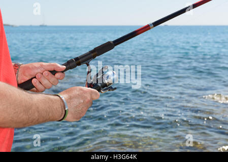 Detail eines Fischers mit einer Angelrute die Hände. Stockfoto