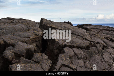 Gehievt und erstarrter Lava Closeup mit Goldadern gegen blauen Himmel und Pazifischen Ozean, Hawaii geknackt. Stockfoto