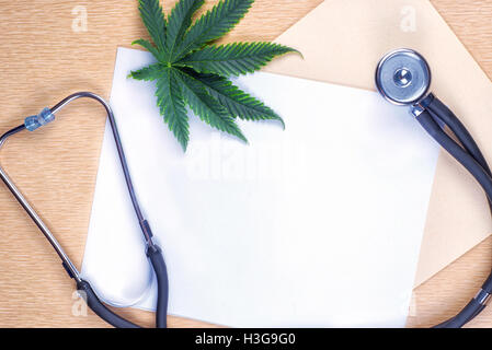 Medizinisches Marihuana Hintergrund mit leerem Papier, Cannabisblatt und Stethoskop Stockfoto