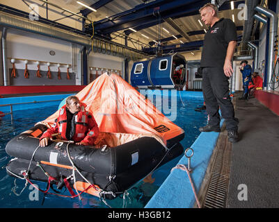 Bremerhaven, Deutschland. 30. September 2016. Eine mock Offshore-Helikopter-Cockpit ist aus der Ausbildungs-Pool von Falck-Sicherheitsdienstleistungen in Bremerhaven, Deutschland, 30. September 2016 aufgehoben. Rescue Diver sichern Bereich, wie sie die Passagiere aussteigen sehen. Personen, die im Offshore-Bereich arbeiten lernen, wie man nach einem Rettungshubschrauber Wasserlandung während der sogenannten "Hubschrauber Unterwasser Escape Training" (HUET) überleben. Foto: INGO WAGNER/Dpa/Alamy Live News Stockfoto