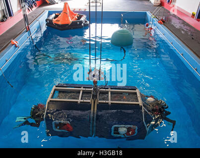 Bremerhaven, Deutschland. 30. September 2016. Eine mock Offshore-Helikopter-Cockpit ist in der Ausbildungs-Pool von Falck-Sicherheitsdienstleistungen in Bremerhaven, Deutschland, 30. September 2016 versenkt. Rescue Diver sichern Bereich, wie sie die Passagiere aussteigen sehen. Personen, die im Offshore-Bereich arbeiten lernen, wie man nach einem Rettungshubschrauber Wasserlandung während der sogenannten "Hubschrauber Unterwasser Escape Training" (HUET) überleben. Foto: INGO WAGNER/Dpa/Alamy Live News Stockfoto