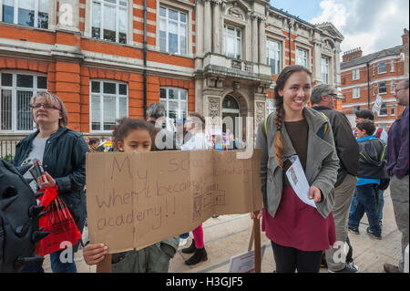 London, UK. 8. Oktober 2016. Ein Kind hält eine Fahne "meiner Schule wurde zerstört, als ein Gewinn Makingin Akademie wurde!"  WIndrush Platz bei der Vorstellung des "Stand Up, Lambeth" eine Reihe von Veranstaltungen gegen die Politik des Rates, fordert es zu stoppen Abriss des Rates Nachlässe, Bibliotheken schließen und lokale Unternehmen mit der Schließung der Brixton Arches verjagt. Aktivisten beschuldigen den arbeitsrechtlichen Rat finanzielle Verschwendung und zu "zerstören unsere Gemeinschaften, rassische und soziale Ungleichheit" und "die Leute von Lambeth zu stehlen die Zukunft. Bildnachweis: Peter Marshall/Alamy Live-Nachrichten Stockfoto