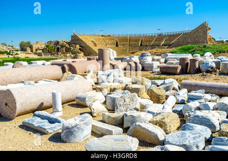 Die erhaltenen und restaurierten Teil des antiken Kolosseums, umgeben von den Artefakten und zerstörte Gebäude, Caesarea, Israel. Stockfoto