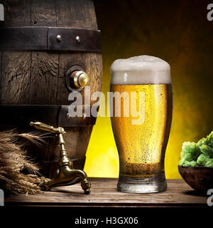 Glas helles Bier und Lauf auf dem Holztisch. Stockfoto