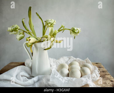 Stillleben mit Tulpen und Eiern auf Holztisch Stockfoto