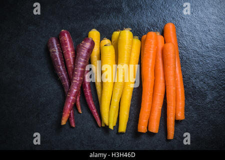 Bunte Karotten Draufsicht auf dunklen Schiefer Stockfoto
