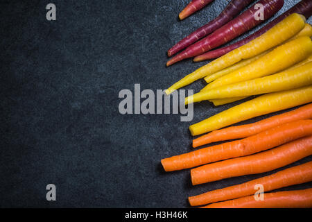 Regenbogen-Karotten Grenze Hintergrund dunkler Schiefer Stockfoto