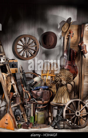 Stillleben mit alten Musikinstrumenten, verschiedene Cowboy Zubehör, Waffe und Armee Ausrüstung Stockfoto