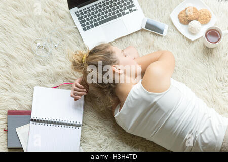 Studentin schlief nach dem Studium zu Hause Stockfoto