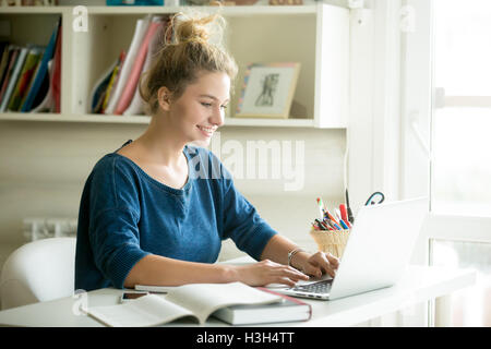 Glückliche Frau arbeitet im gemütlichen Heim-Büro Stockfoto