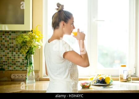 Porträt von einer attraktiven Frau trinken Saft der Küche Stockfoto