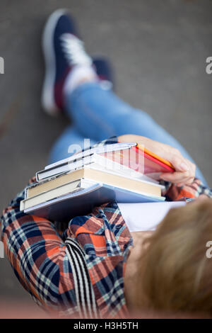 Studentin mit einem Haufen von Lehrbüchern und notebooks Stockfoto