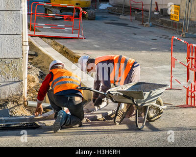 Arbeiter verlegen Pflastersteine Kerb - Frankreich. Stockfoto