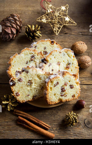 Weihnachten festlich Früchtebrot (Kuchen, Obstkuchen) auf rustikalem Holzbrett mit Zimt und Dekor - hausgemachte Weihnachtsbäckerei Stockfoto