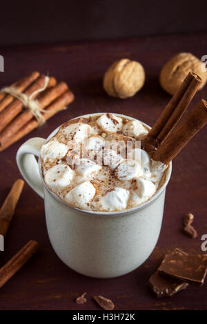 Heiße Schokolade trinken mit Marshmallows, Schokoladenstückchen und Zimtstangen über rustikalen hölzernen Hintergrund - hausgemachte Getränk für WLAN Stockfoto