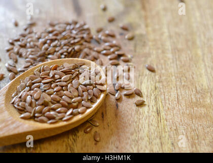 Leinsamen in Holzlöffel auf Holztisch Stockfoto