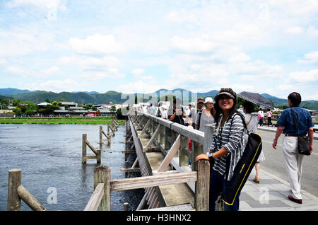 Thai-Frau und japanischen Menschen und Reisende Ausländer posieren für Porträt und zu Fuß auf Togetsukyo Brücke über den Fluss Oi eine Stockfoto