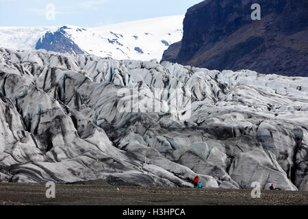 Touristen in Asche bedeckt Skaftafell Gletscher und Ende Moräne Vatnajökull-Nationalpark in Island Stockfoto