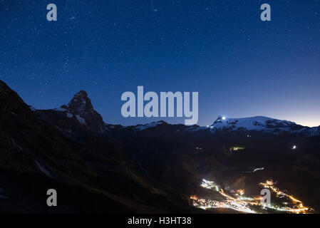 Luftaufnahme von Breuil Cervinia Dorf Leuchten in der Nacht, die berühmten Skigebiet im Aostatal, Italien. Wunderbaren Sternenhimmel über Stockfoto